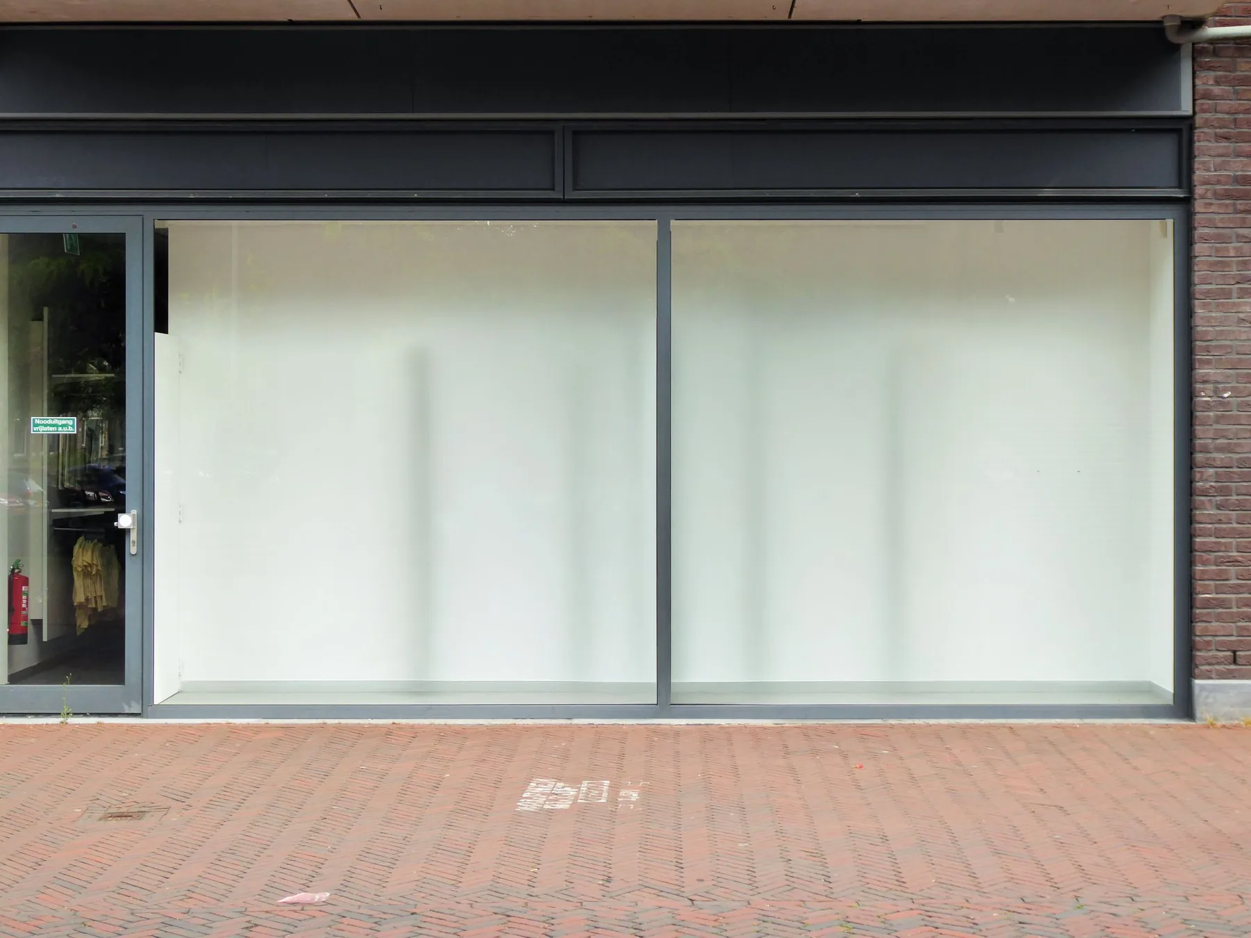 How most retail space arrives. Whited-out glass, a blank fascia and nothing behind it.